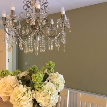 Olive-green dining room with chandelier